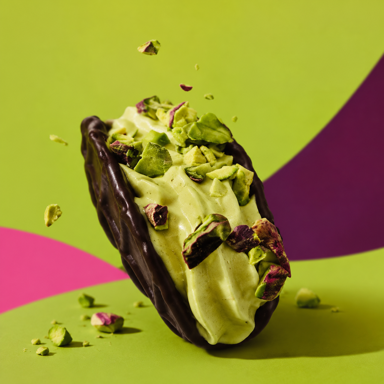 Waffle taco coated in dark chocolate and filled with pistachio cream and chopped pistachios
